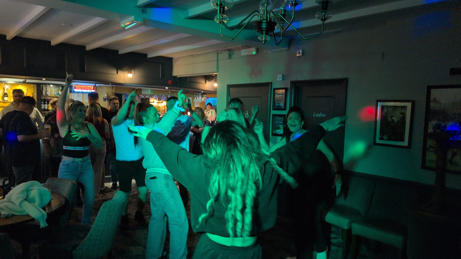 Guests dancing at a pub party with DJ lighting