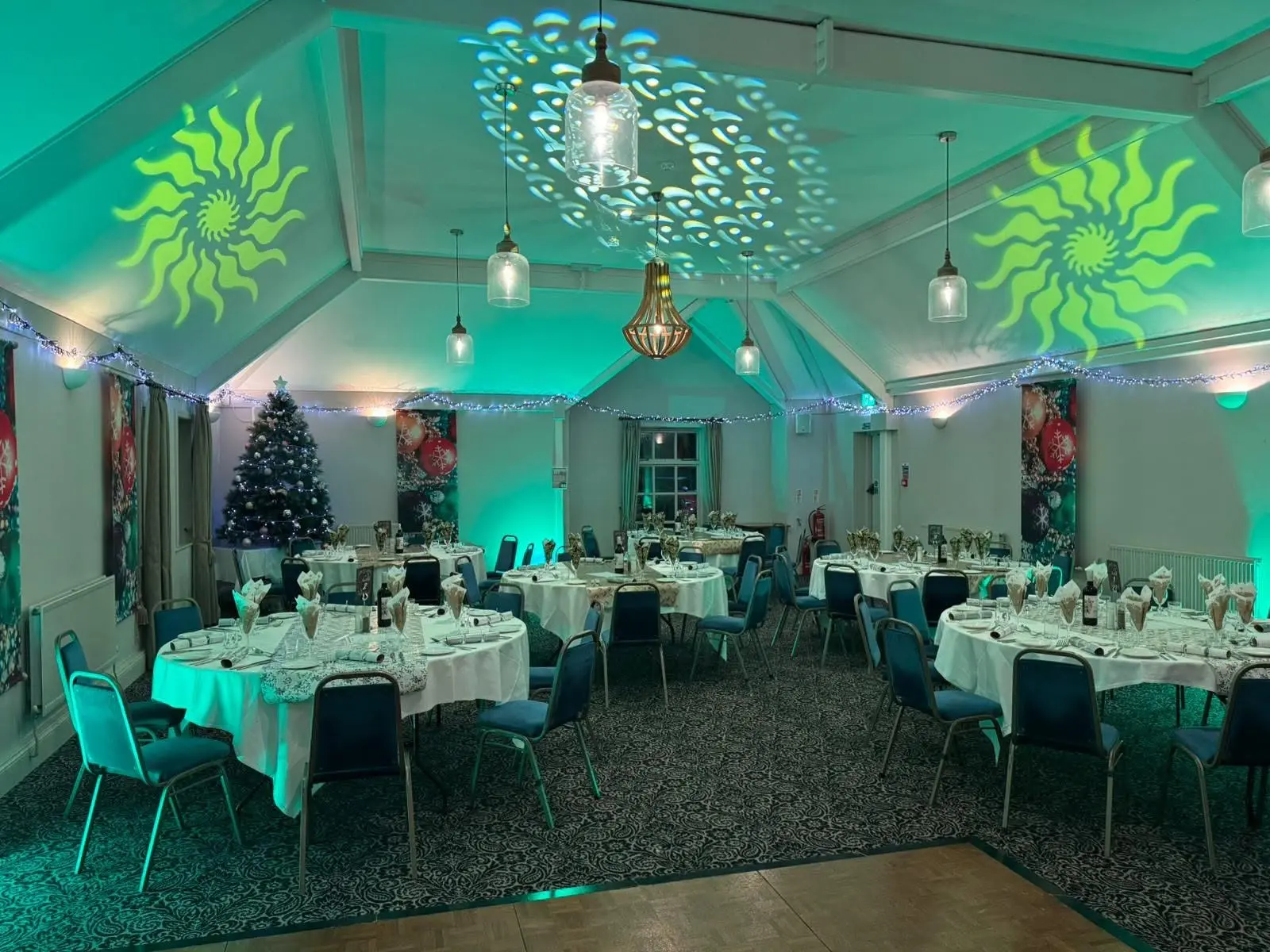 Christmas party room with teal uplighting and gobo patterns