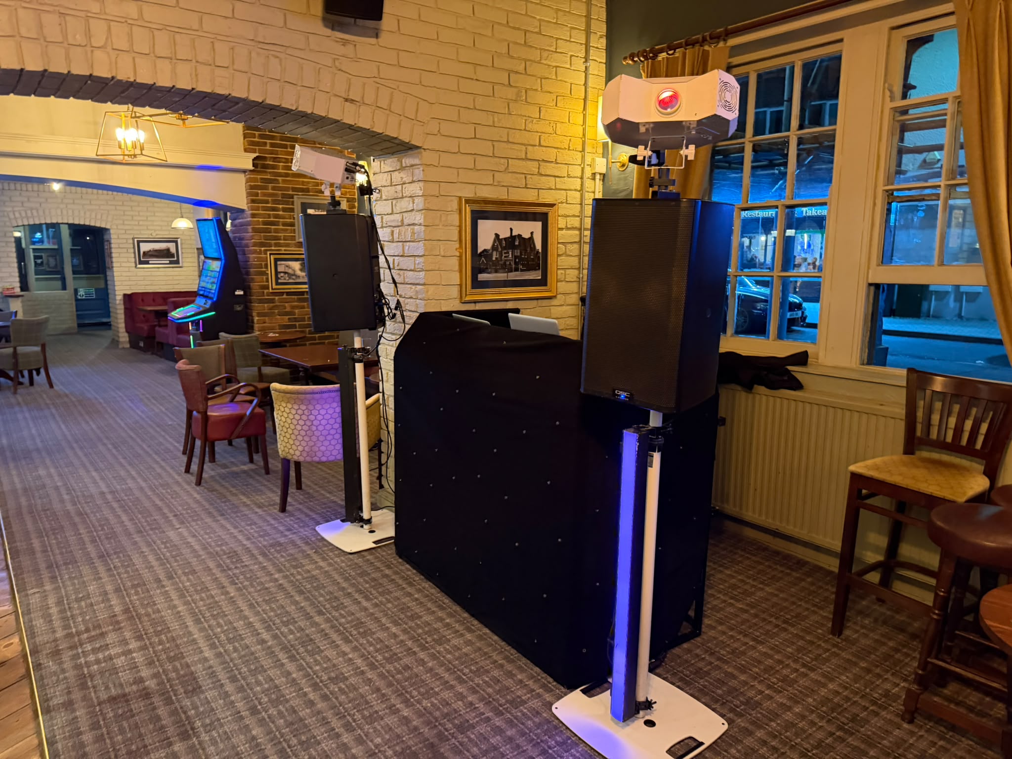 DJ booth with speakers and lighting set up in a Sussex pub