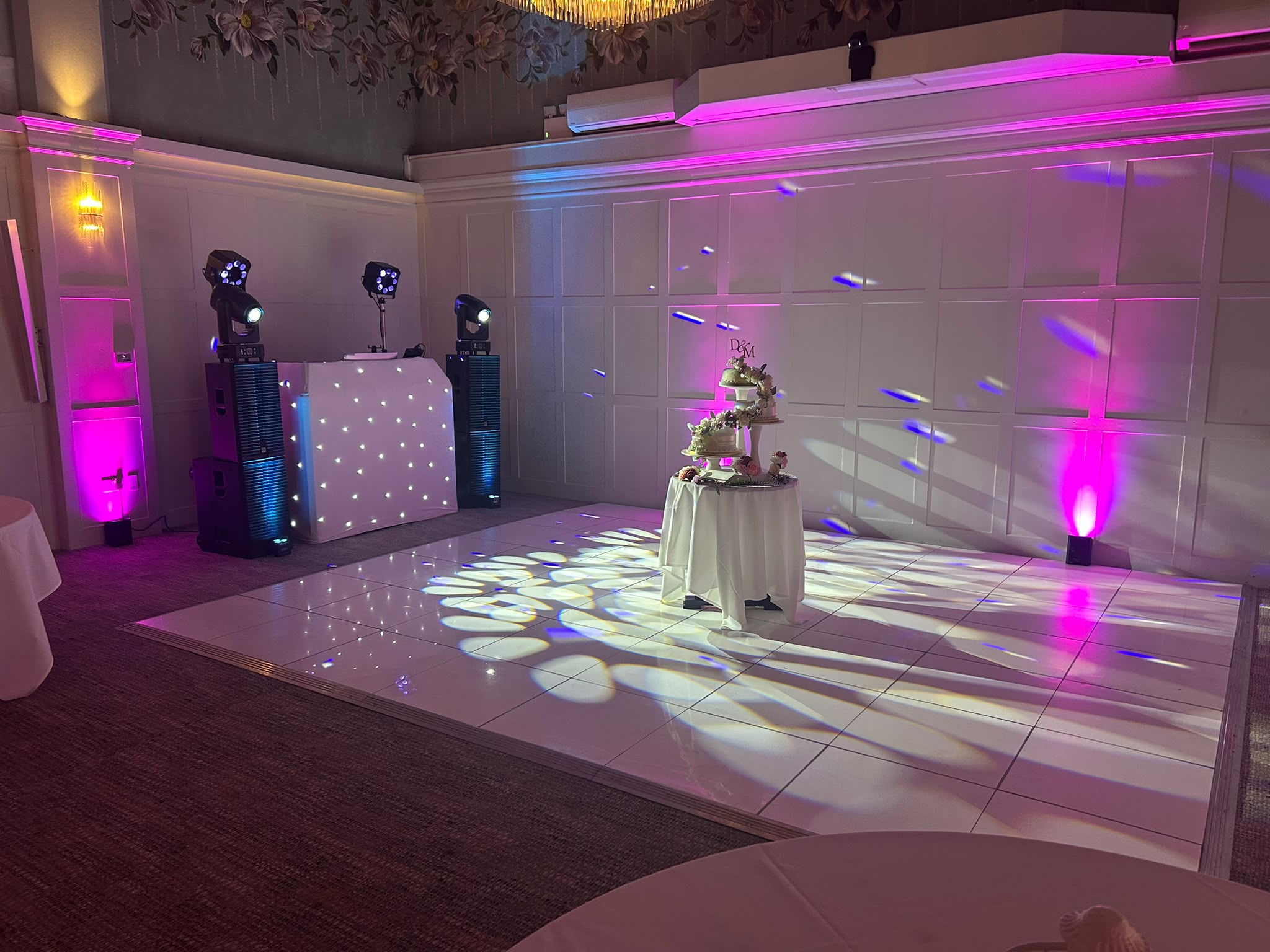 Pink uplighters, DJ booth and LED dance floor at a Sussex wedding
